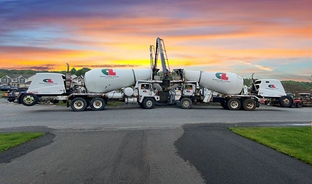 trucks pouring concrete at sunrise